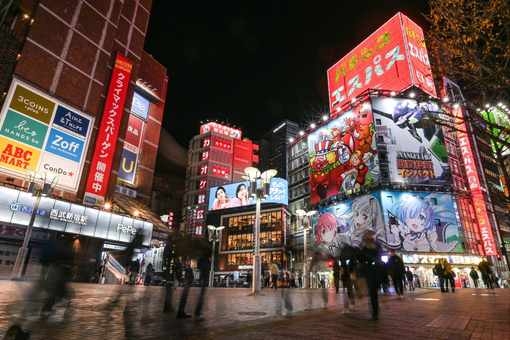 Tourists and locals in the Shinjuku district of central Tokyo at night. Photo: AFP