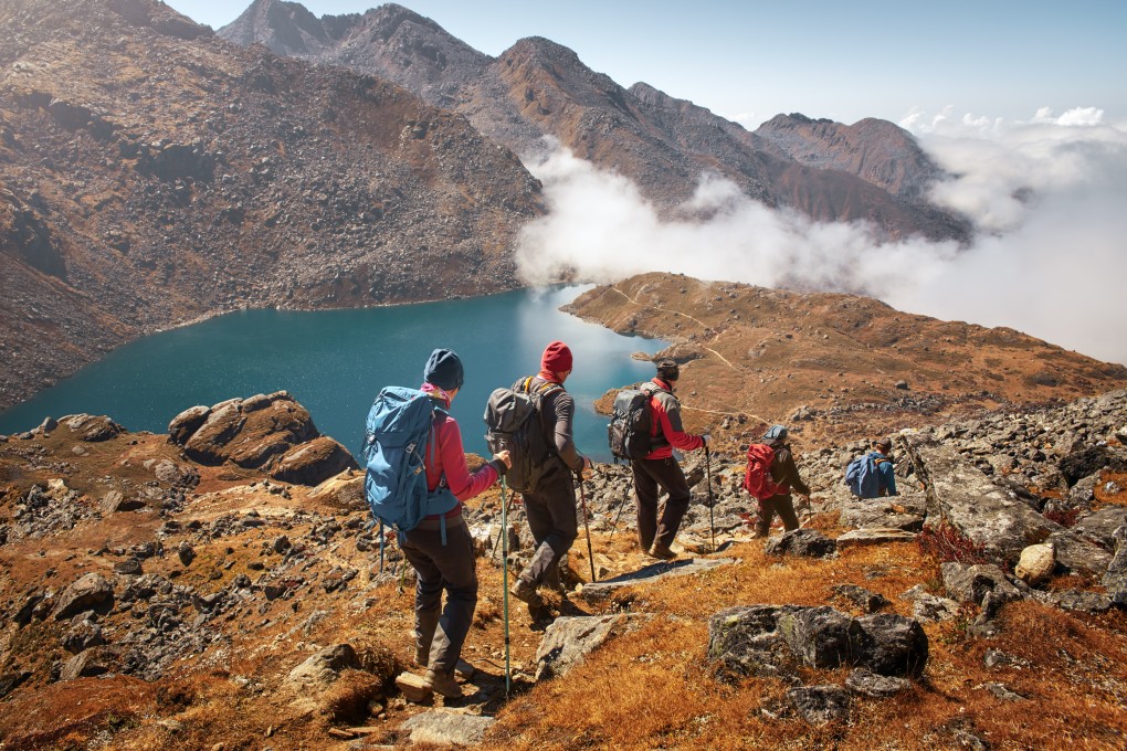 Tourists descend mountain trail to lake during a hike in Langtang National Park in Nepal. Photo: Shutterstock