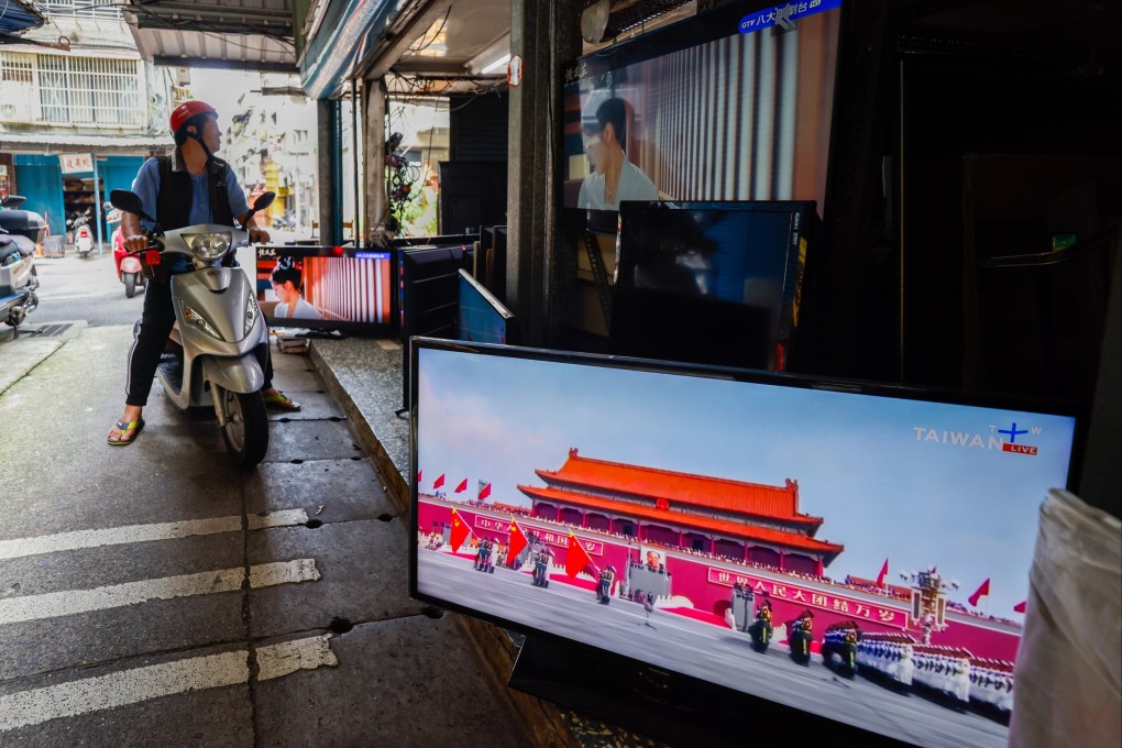A Television broadcast of the military parade in China is seen at a TV store as people pass by in Taipei, Taiwan, on Wednesday. Photo: EPA