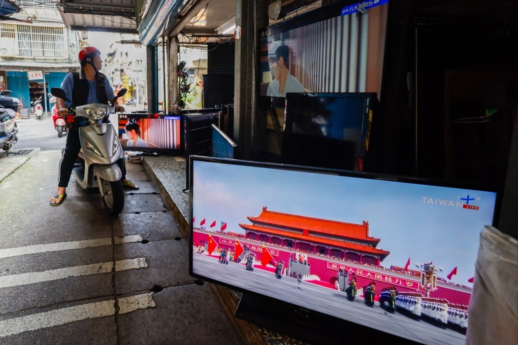 A Television broadcast of the military parade in China is seen at a TV store as people pass by in Taipei, Taiwan, on Wednesday. Photo: EPA