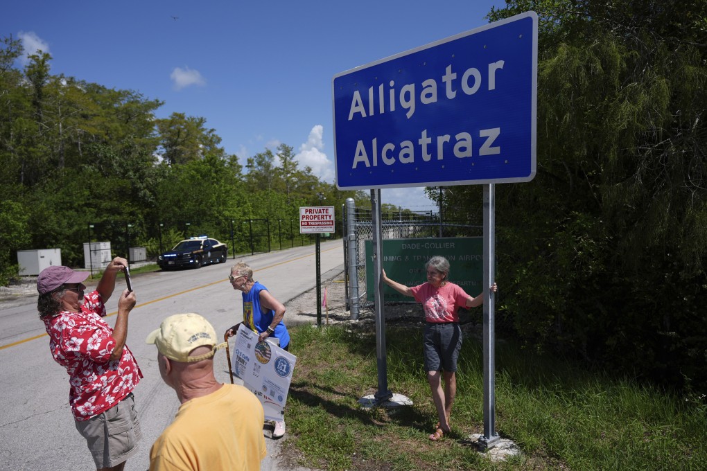 People take pictures in front of a sign reading “Alligator Alcatraz” in the Florida Everglades in August. Photo: AP