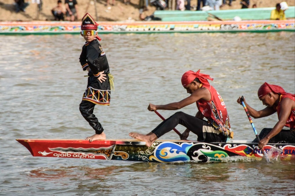 Rayyan Arkan Dikha (left), an 11-year-old boy who went viral for his calm dance on the bow of a traditional longboat. Photo: AFP