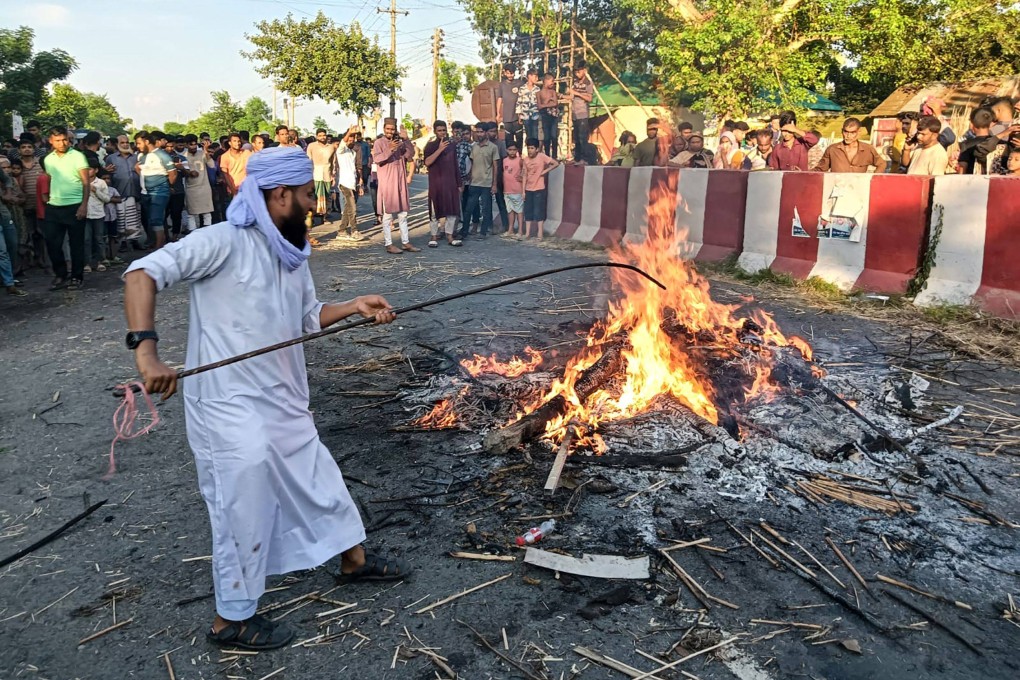 Men exhume Nurul Haques shrouded corpse and burn through a street in Rajbari district on Saturday. Photo: AFP