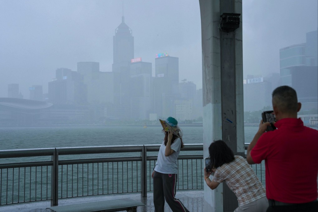 Visitors take pictures amid poor visibility as Tapah approaches Hong Kong, with the No 3 typhoon signal in force. Photo: Karma Lo