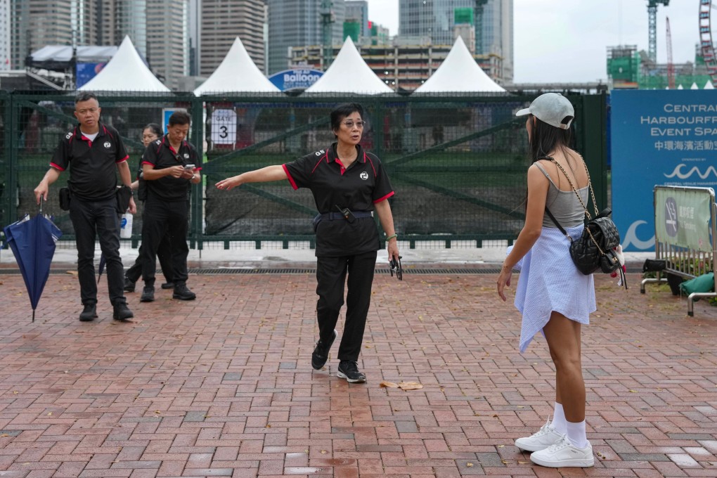 Security staff speak to a visitor at the AIA International Balloon Festival in Central on Sunday morning. Photo: Karma Lo