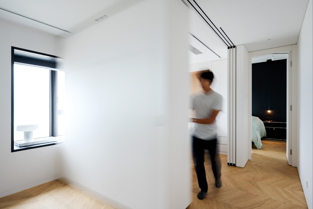 A sliding wall shrinks or expands the living area and guest room at this flat in West Kowloon designed by Norman Ung, co-founder of design studios Form and Design Eight Five Two (Deft). Photo: Eugene Chan