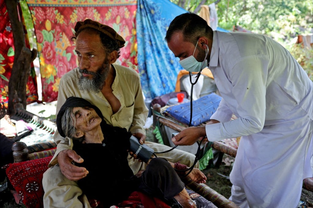 A man holds his elderly mother as a doctor checks her, in quake-hit Kunar province. Photo: Reuters