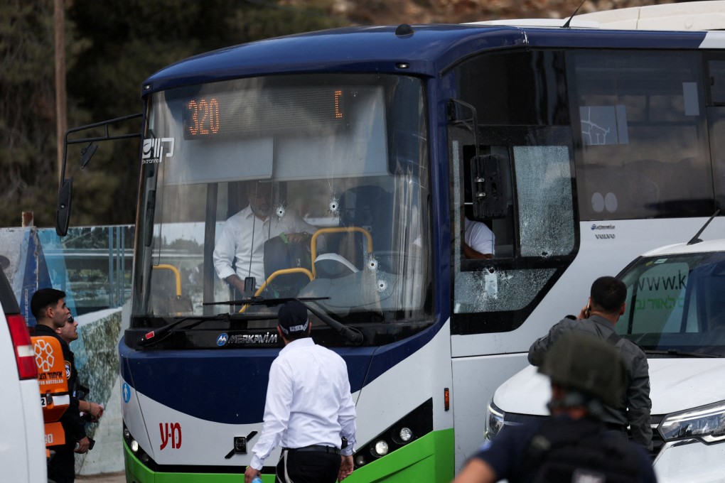 People inspect a bus with bullet holes in the windscreen at the scene of the shooting. Photo: Reuters