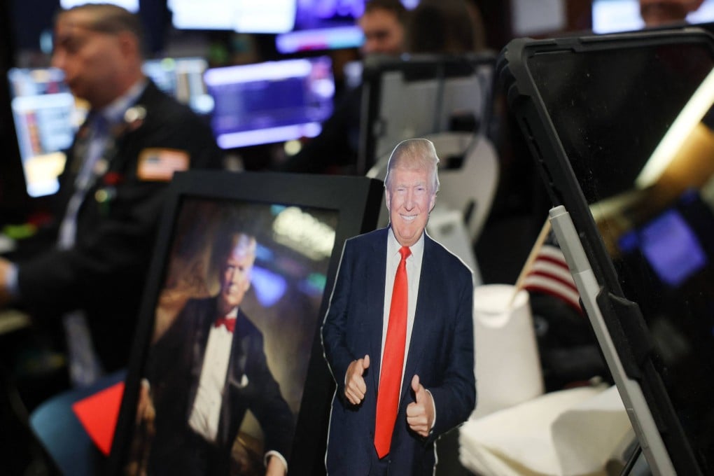 Pictures of US President Donald Trump sit on a desk as traders work on the floor of the New York Stock Exchange. Photo: AFP