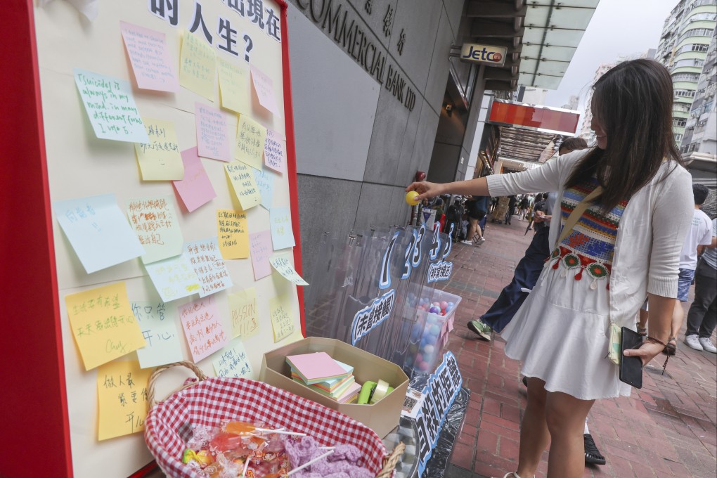 A woman takes part in a poll at a street booth run by the Student Alliance on Student Suicide, to raise public awareness of student deaths by suicide, the reasons behind suicide attempts and to call for greater community concern about mental well-being, in Mong Kok on September 8, 2024. Photo: Edmond So