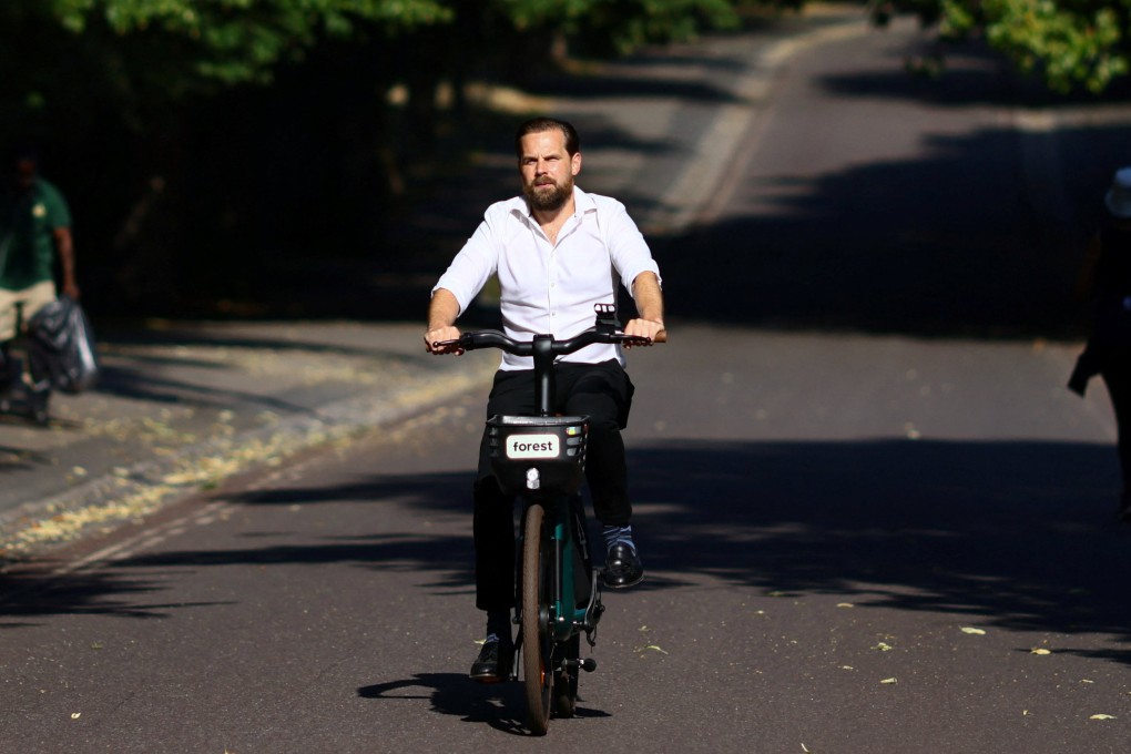 A man rides a hired e-bike up a hill in Greenwich Park, London. Photo: Reuters