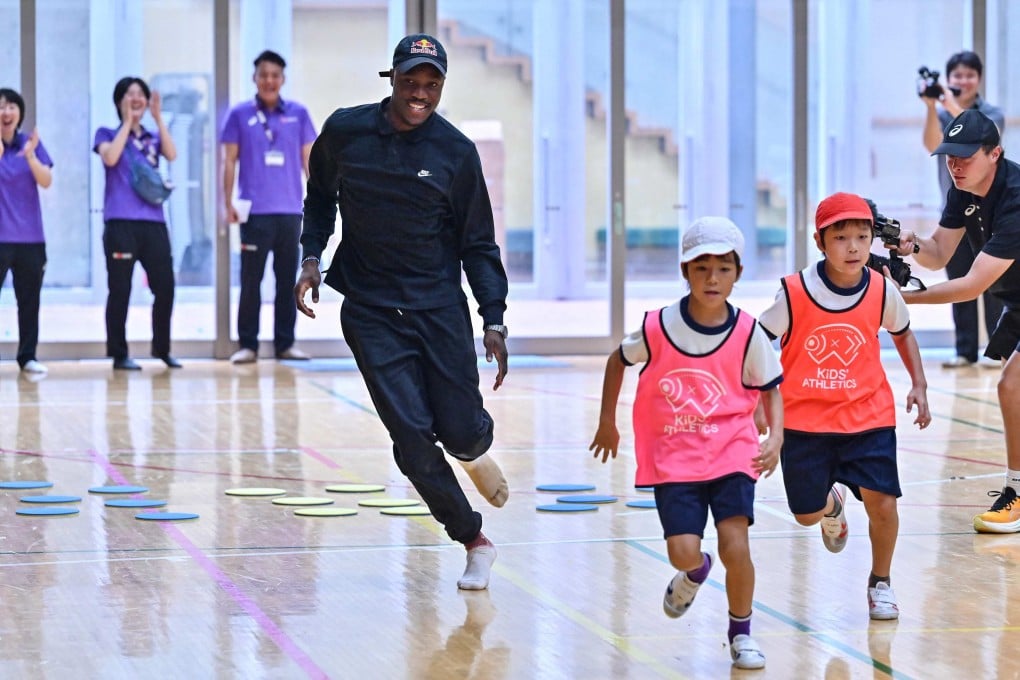 Olympic 200m champion Letsile Tebogo runs with children around a course during a visit to a primary school gymnasium on Tuesday before the start of the World Athletics Championships in Tokyo. Photo: AFP