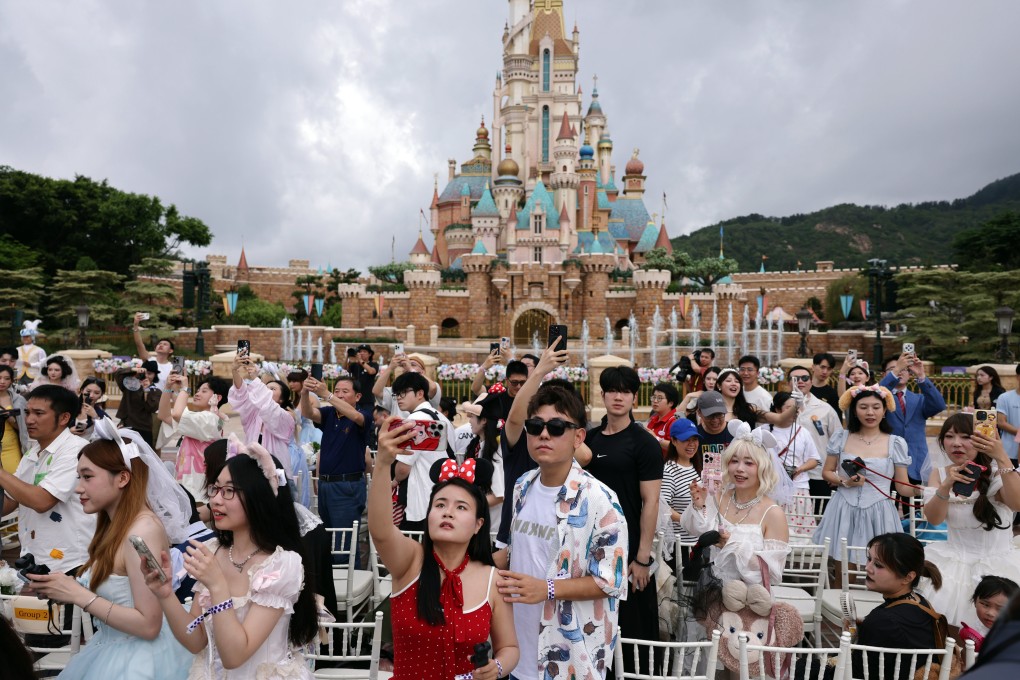 Mainland couples celebrate Chinese Valentine’s Day with Disneyland mascots in front of the Castle of Magical Dreams at Hong Kong Disneyland on May 20. Photo: Nora Tam