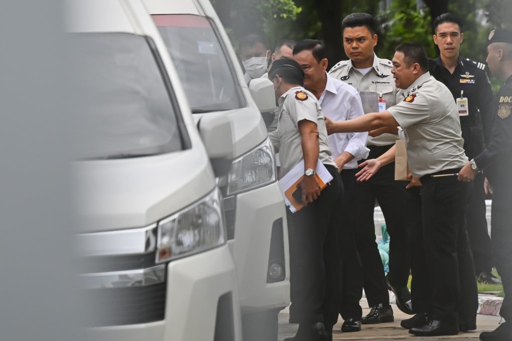 Thaksin Shinawatra (second from left) is escorted into a vehicle as he leaves the Supreme Court in Bangkok, Thailand, on Tuesday. Photo: AP