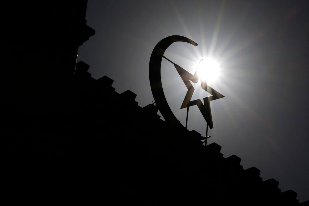 Late morning sunlight silhouettes the star and crescent at the entrance of the Great Paris Mosque. Photo: AFP