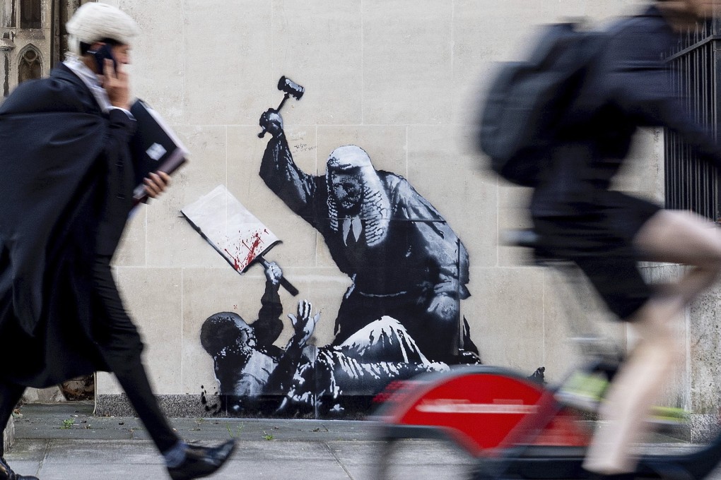 A Banksy artwork portraying a judge beating a protester with a gavel, at the Royal Courts of Justice in London. Photo: Banksy via AP