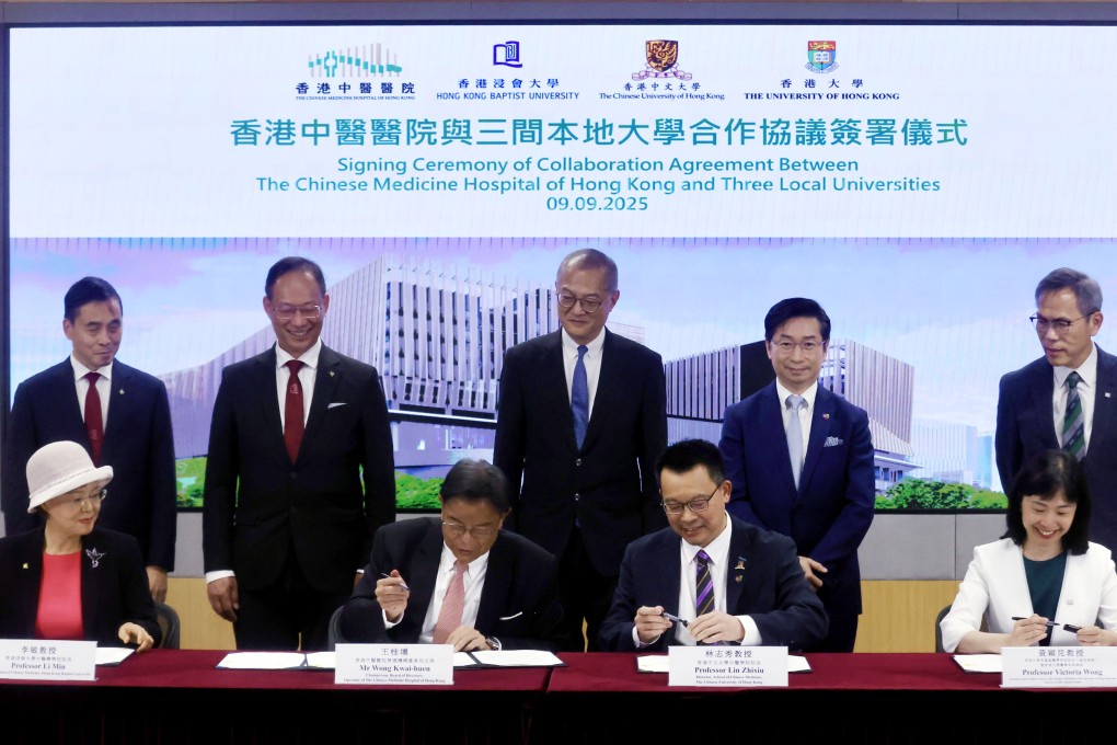 Representatives of three local universities sign agreements with the new hospital as health chief Lo Chung-mau (standing, centre) looks on. Photo: Jonathan Wong