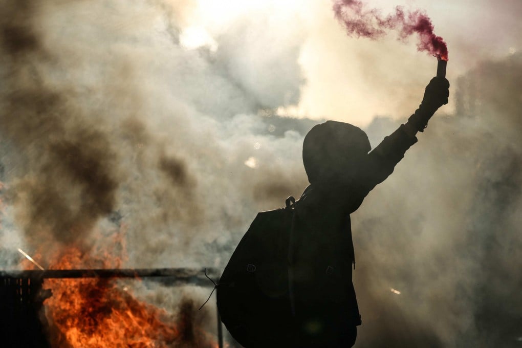 A protester brandishes a flare during the “Bloquons Tout”, or “Block Everything”, protests on Wednesday. Photo: AFP