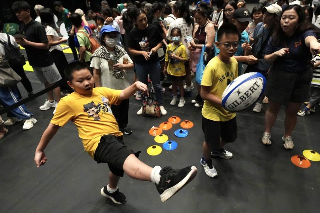 Youngsters try kicking a rugby ball during a public hands-on experience of National Games activities at Freespace in the West Kowloon Cultural District on August 23. Photo: Karma Lo