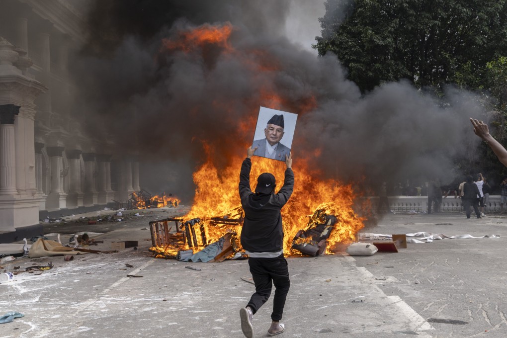 A protester prepares to burn a picture of Nepal’s former prime minister while storming the Singha Durbar palace in Kathmandu on Monday. Observers warn that Beijing should prepare for further instability among neighbouring Asian nations. Photo: EPA