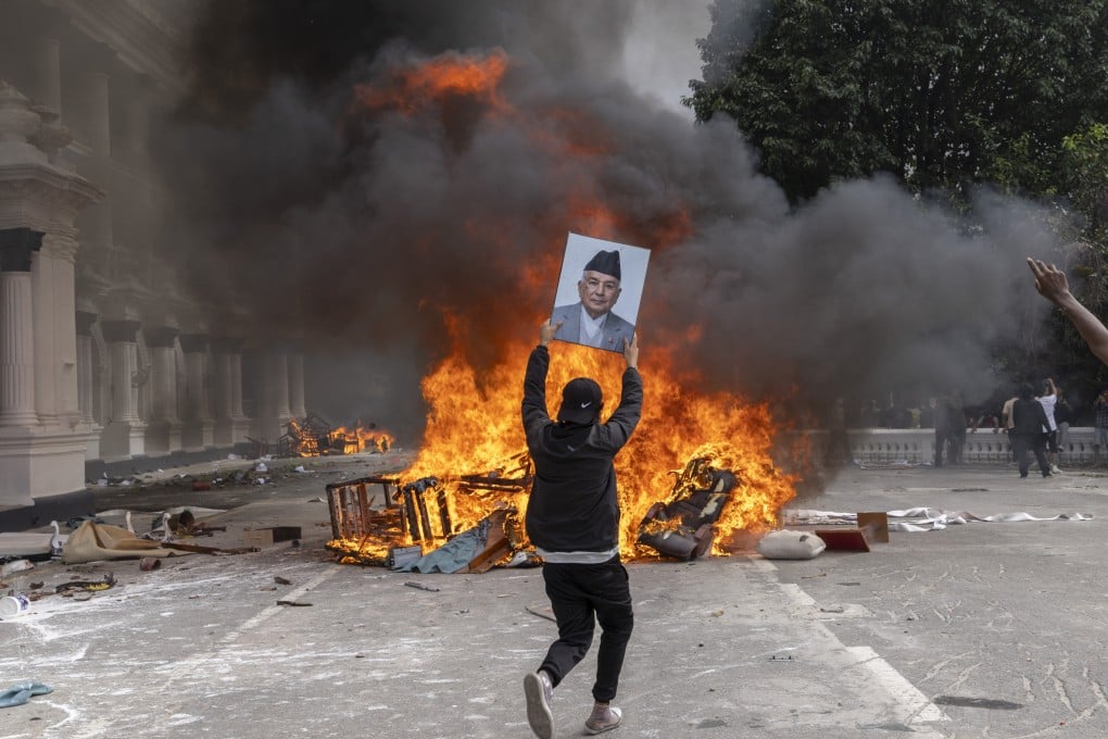 A protester prepares to burn a picture of Nepal’s former prime minister while storming the Singha Durbar palace in Kathmandu on Monday. Observers warn that Beijing should prepare for further instability among neighbouring Asian nations. Photo: EPA