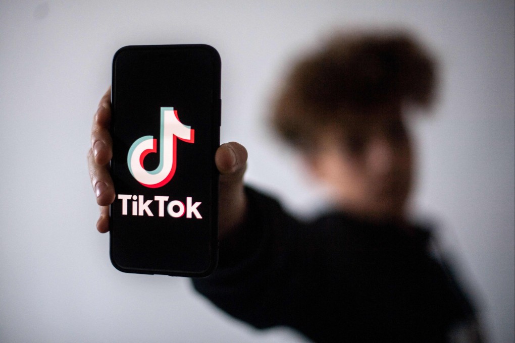 A teenager holds a smartphone with the logo of Chinese social network TikTok in Nantes, western France. Photo: AFP