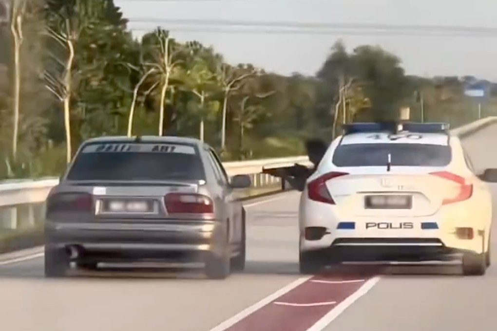 A police car chasing a 16-year-old driver in Kuala Terengganu, Malaysia, with one officer pointing a submachine gun at him on Monday. Photo: Projek Hitam/X