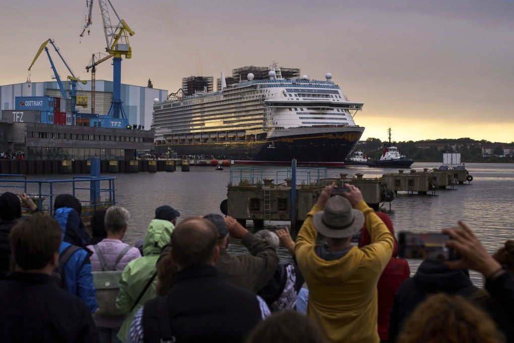 People watch a Disney Adventure cruise ship depart from a harbour in Germany. Photo: AP