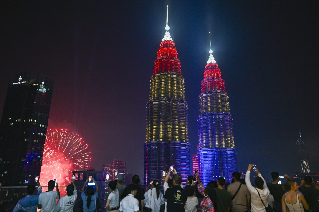 People take photos of fireworks near the Petronas Twin Towers in Kuala Lumpur in celebration of Malaysia’s 68th anniversary of independence on August 31. Photo: Xinhua