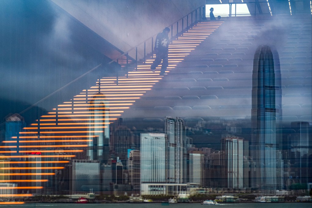 A man walks down an illuminated staircase at M+ in West Kowloon as the Hong Kong skyline is reflected in glass. For all its marquee exhibitions, the West Kowloon Cultural District has yet to cement itself as a must-visit for both locals and tourists. Photo: Eugene Lee