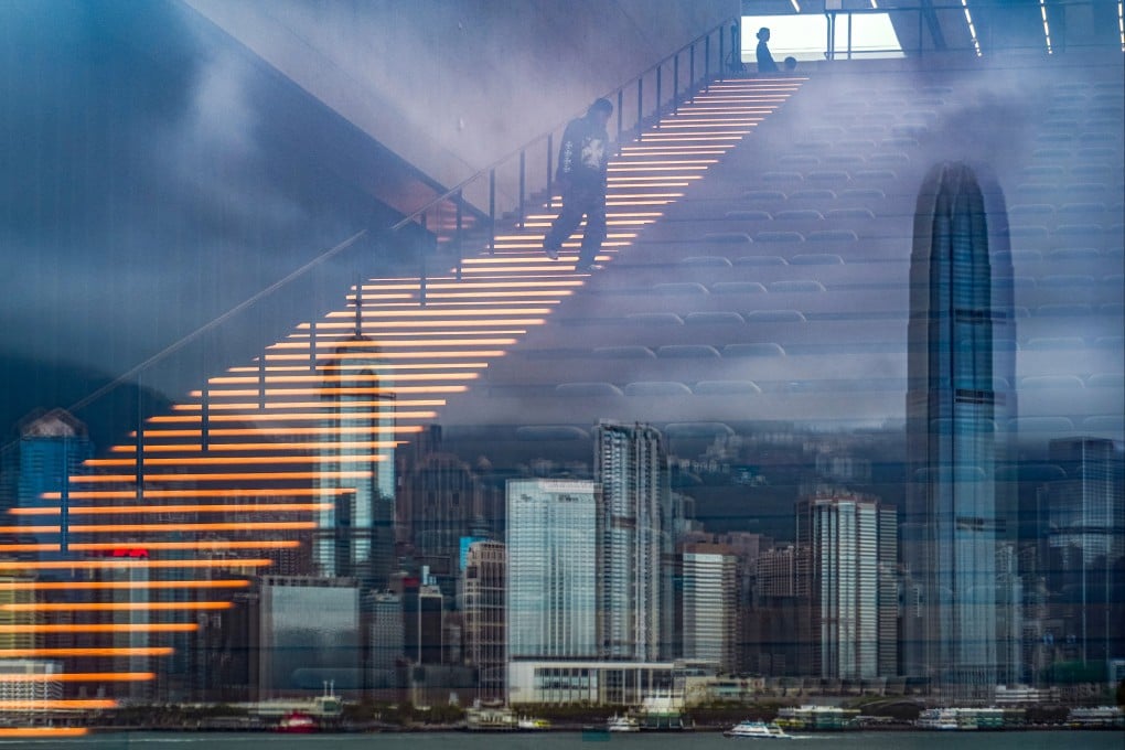 A man walks down an illuminated staircase at M+ in West Kowloon as the Hong Kong skyline is reflected in glass. For all its marquee exhibitions, the West Kowloon Cultural District has yet to cement itself as a must-visit for both locals and tourists. Photo: Eugene Lee