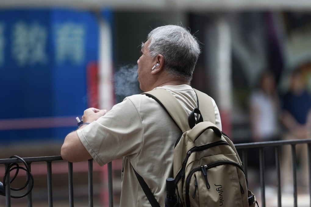 A man vapes in the street near a bus stop at Hang Hau. Photo: Elson Li