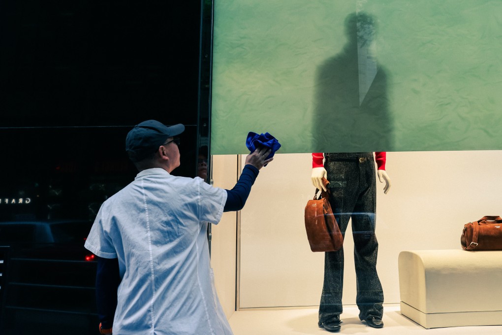 A worker cleans a window display in Central. Photo: Nora Tam
