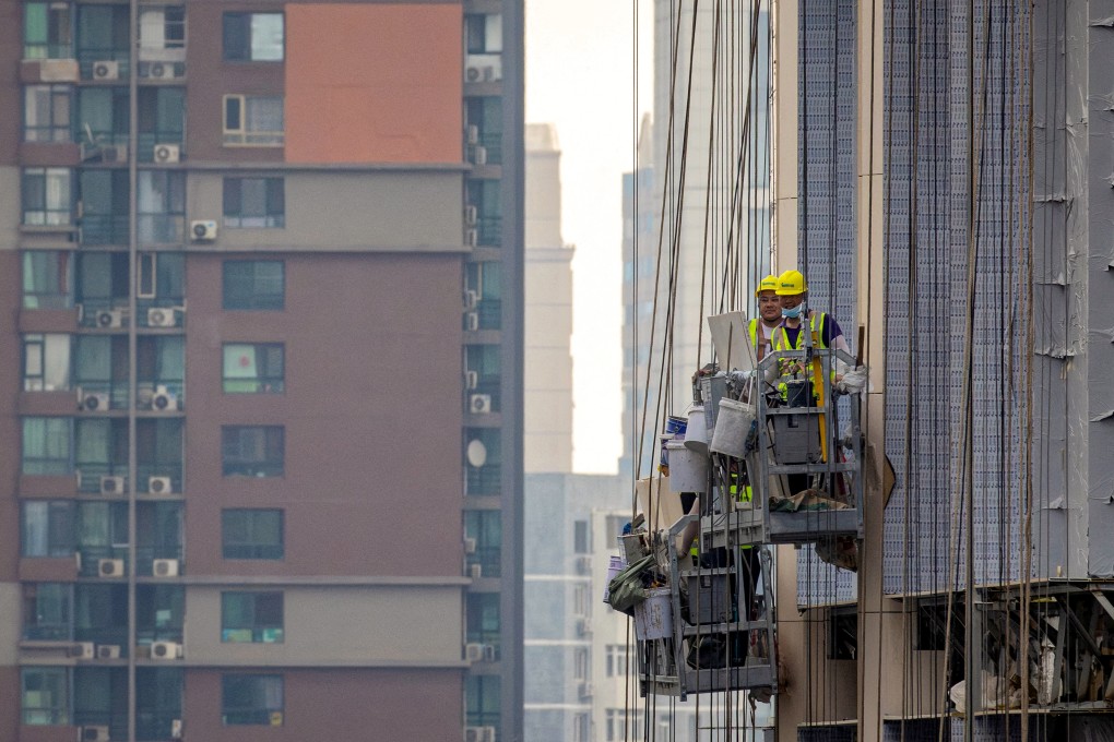 FILE PHOTO: Men work at the construction site of an apartment building in Beijing, China, July 29, 2023. REUTERS/Thomas Peter/File Photo