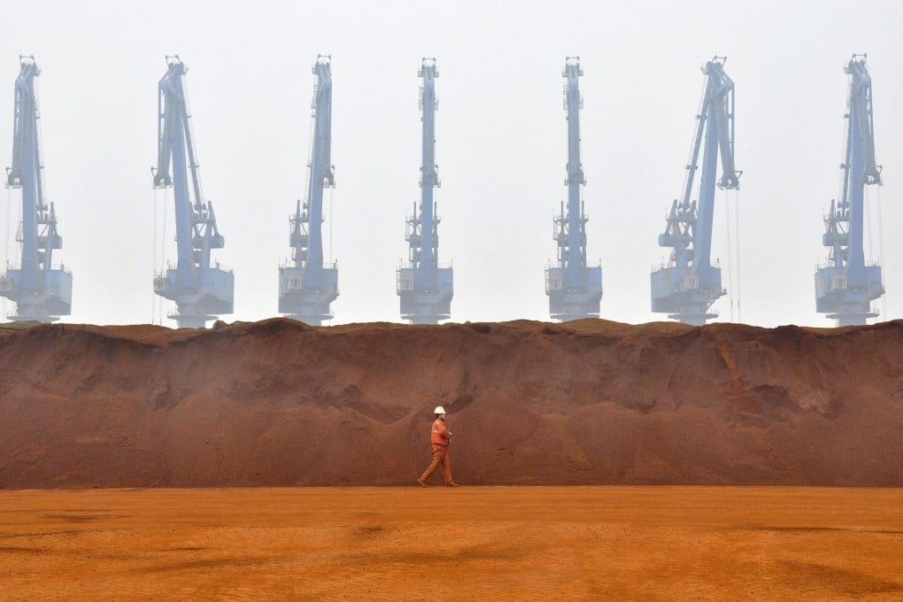 A worker walks past a pile of iron ore from Australia at a port in Tianjin, northern China. Australia relies on Chinese purchases of iron ore and several other products. Photo: Reuters