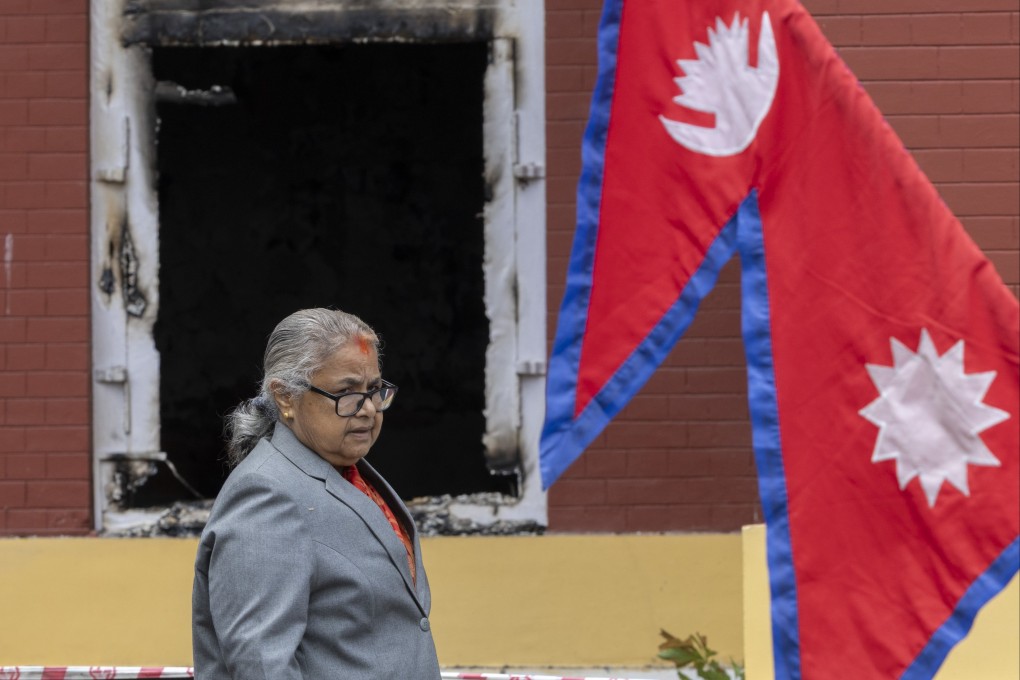 Nepalese Prime Minister Sushila Karki looks on during the swearing-in ceremony of new ministers in front of the President’s Office, which had been set on fire by protesters, in Kathmandu on Monday. Photo:  EPA