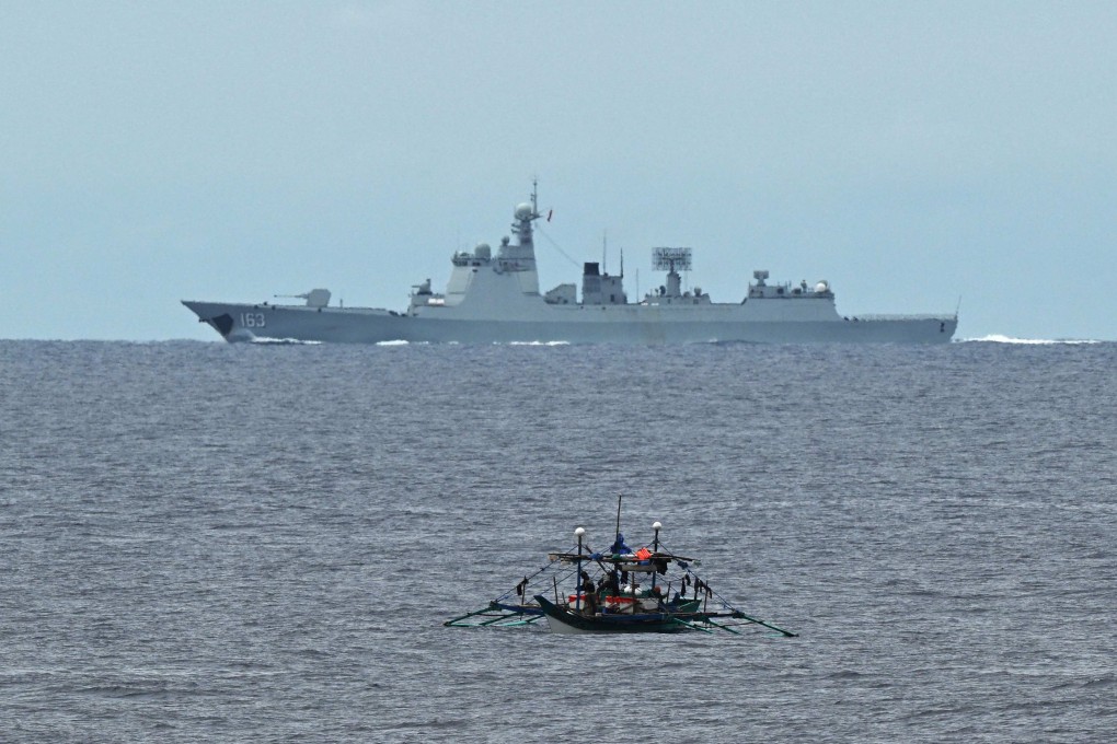 A Chinese navy ship sails past a Philippine fishing boat near Scarborough Shoal in the disputed South China Sea on September 2. Photo: AFP