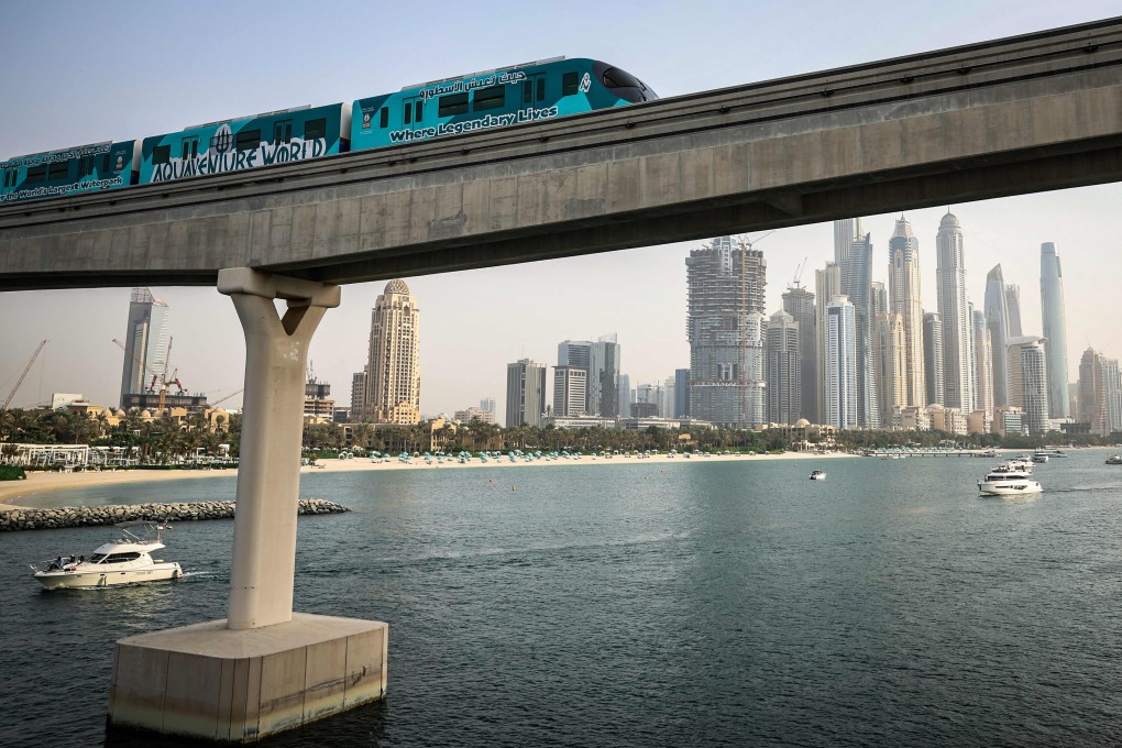 A train runs over a section of Dubai’s Palm Monorail, with a backdrop of the city’s high rise buildings on August 28, 2025. The monorail connects the Palm Jumeirah to the mainland, with a planned further extension to the Red Line of the Dubai Metro. The line, which is the first monorail in the Middle East opened in April 2009. (Photo by FADEL SENNA / AFP)