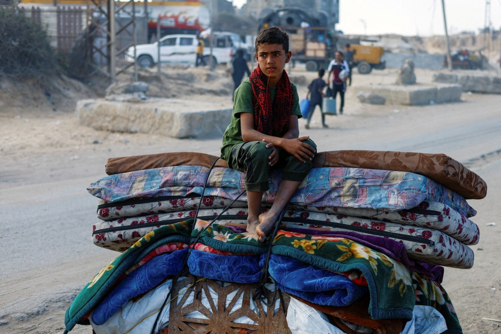 A displaced Palestinian boy, fleeing northern Gaza due to an Israeli military operation, sits atop belongings as he moves southward on Wednesday. Photo: Reuters