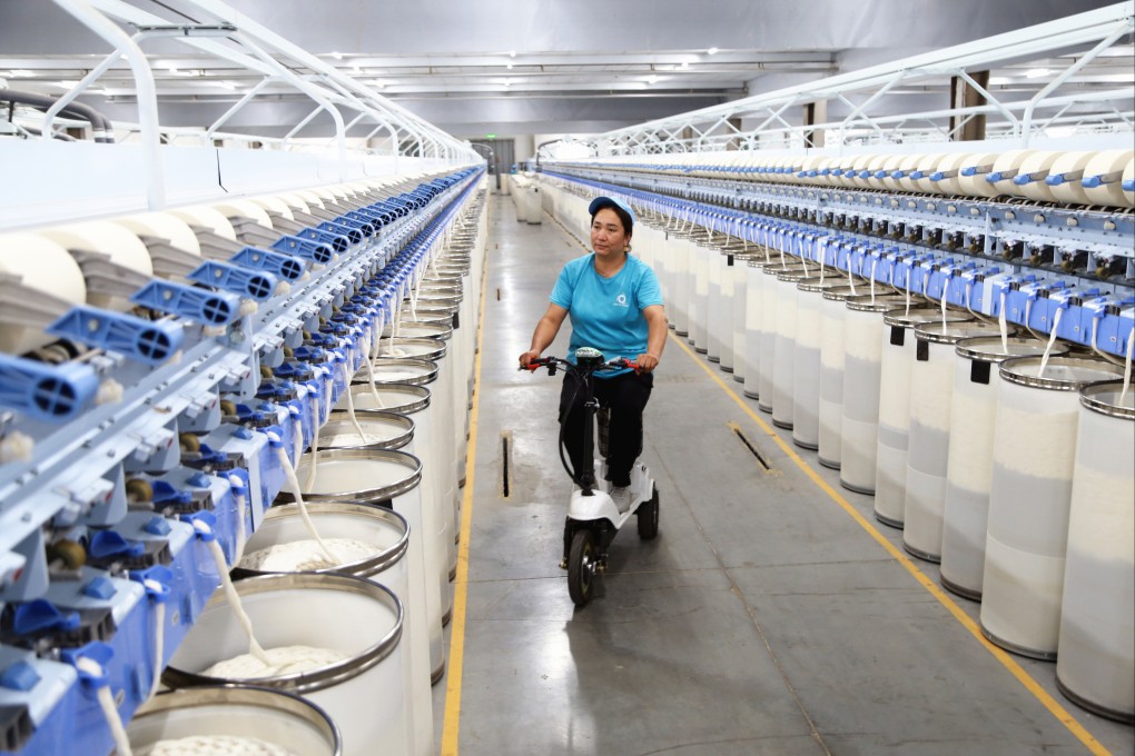 A worker inspects a textile production line at a factory in China’s northwestern Xinjiang Uygur autonomous region. Exports from the region to the United States are surging despite Washington’s 2022 trade restrictions targeting the region. Photo: Getty Images