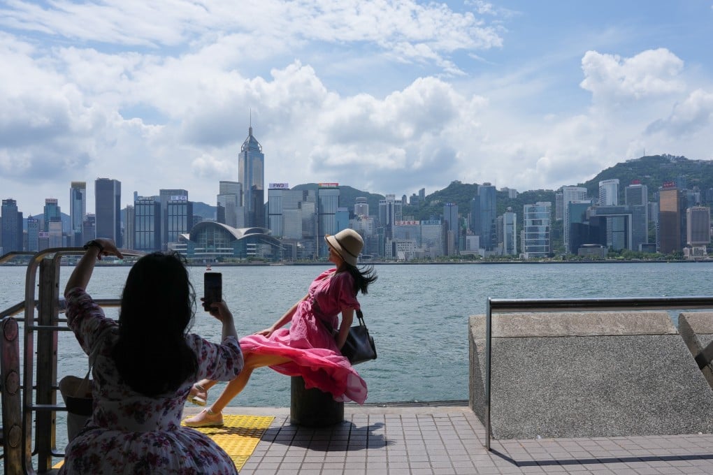 Visitors take photos at the Tsim Sha Tsui waterfront amid the No 1 typhoon standby signal. Photo: Jelly Tse