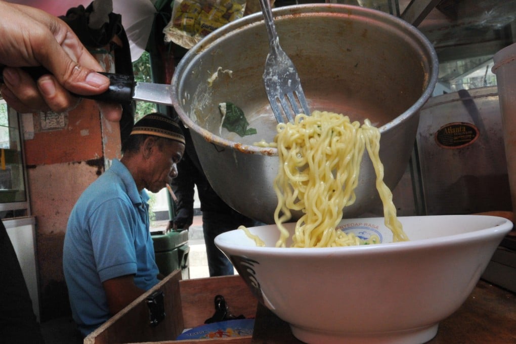 A vendor prepares instant noodles produced by the Indofood company at a stall in Jakarta. Photo: AFP via Getty Images