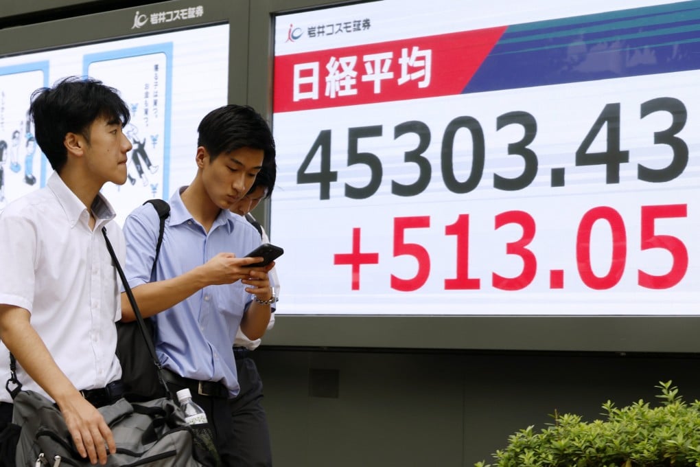 Pedestrians walk past a stock market indicator board in Tokyo on September 18 as the index soars following the US Federal Reserve’s decision to cut interest rates. Photo: EPA