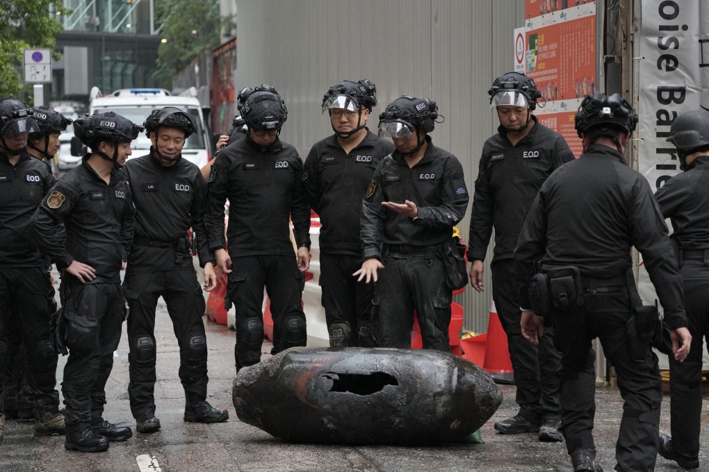 Officers from the explosive ordnance disposal bureau stand beside the shell casing on Pan Hoi street in Quarry Bay. Photo: Karma Lo