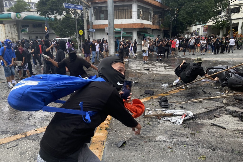 Protesters scuffle with anti-riot police in Manila on Sunday. Photo: EPA