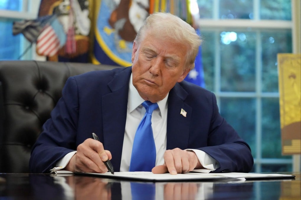 US President Donald Trump signs an executive order on the gold card visa in the Oval Office on Friday. Photo: Reuters