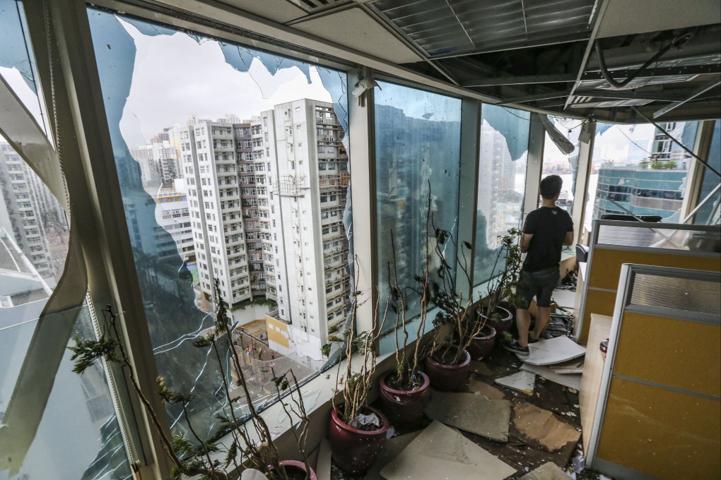 A man inspects damage to the windows of an office in One Harbourfront in Hung Hom after Typhoon Mangkhut hit Hong Kong in 2018. Photo: Felix Wong