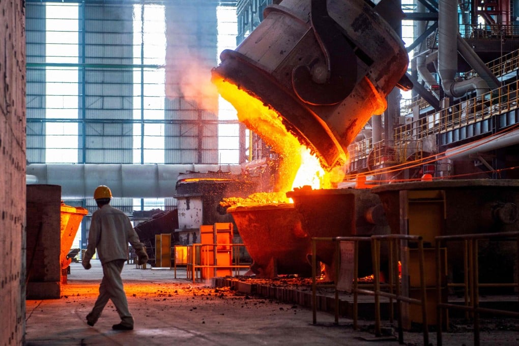 A worker walks past molten steel at a steel factory in China’s eastern Jiangsu province. The Chinese steel industry is plagued by overproduction and weak demand. Photo: AFP