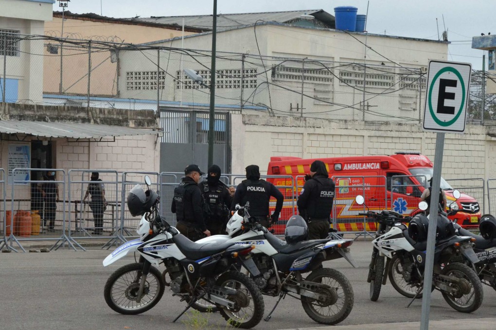 Police officers stand guard outside the main prison in Machala, Ecuador, on Monday, where 13 inmates and a prison guard were killed in clashes. Photo: AFP