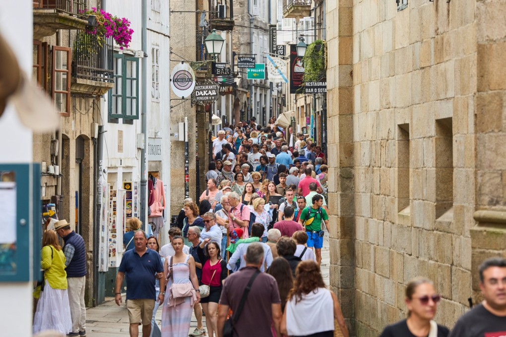 Pilgrims and tourists walk in the old centre of Santiago de Compostela, a Spanish city struggling with overtourism. Photo: AP